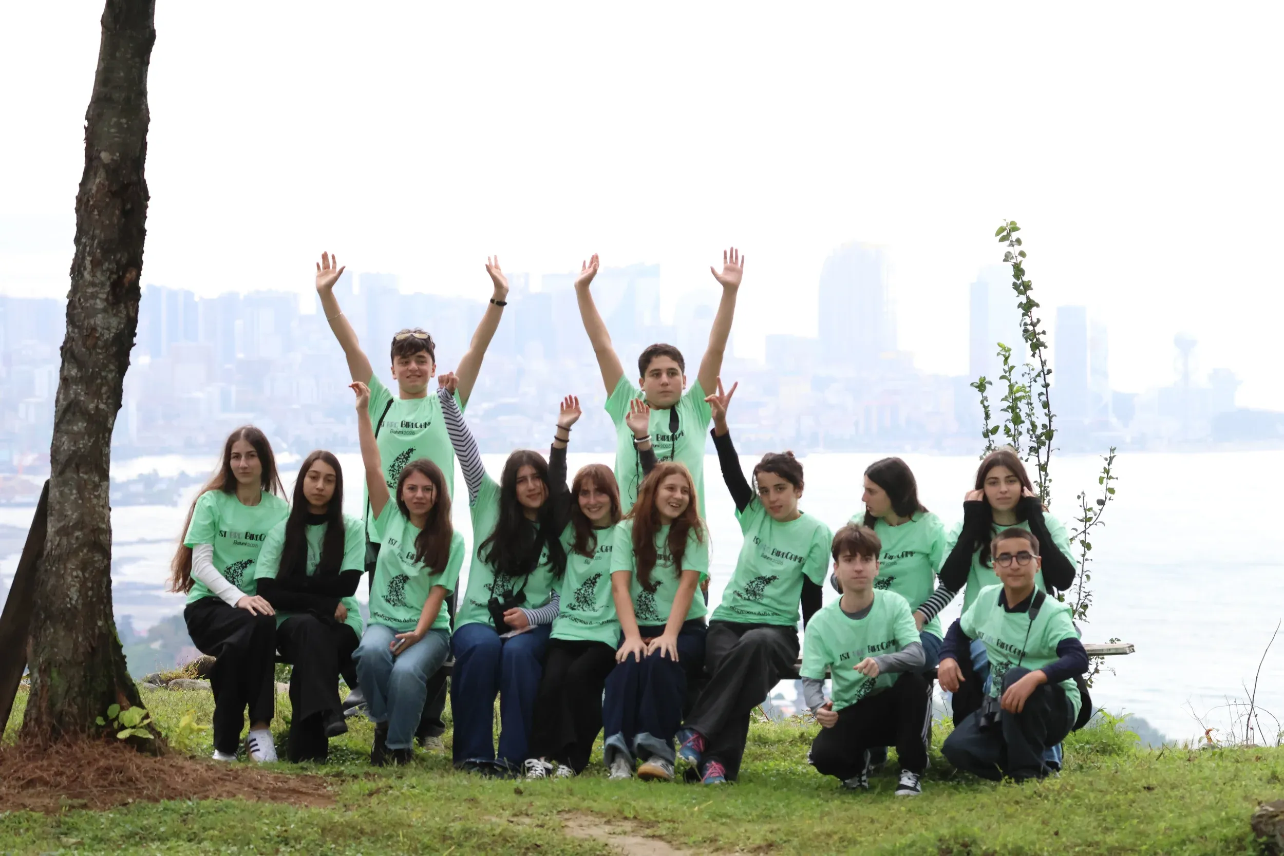 Bird camp students in green T-shirts posing together outdoors
