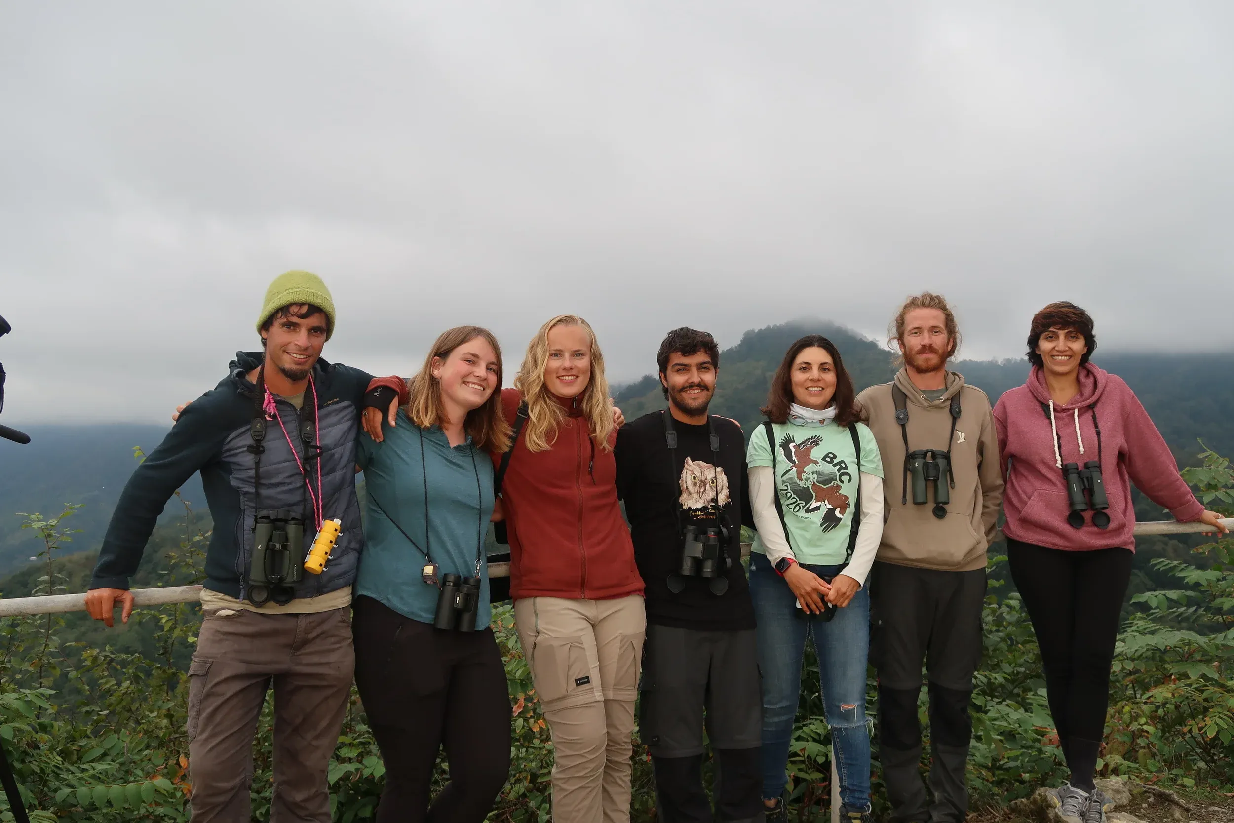 Seven counters standing together at Station 2 with misty wooded hills behind them.