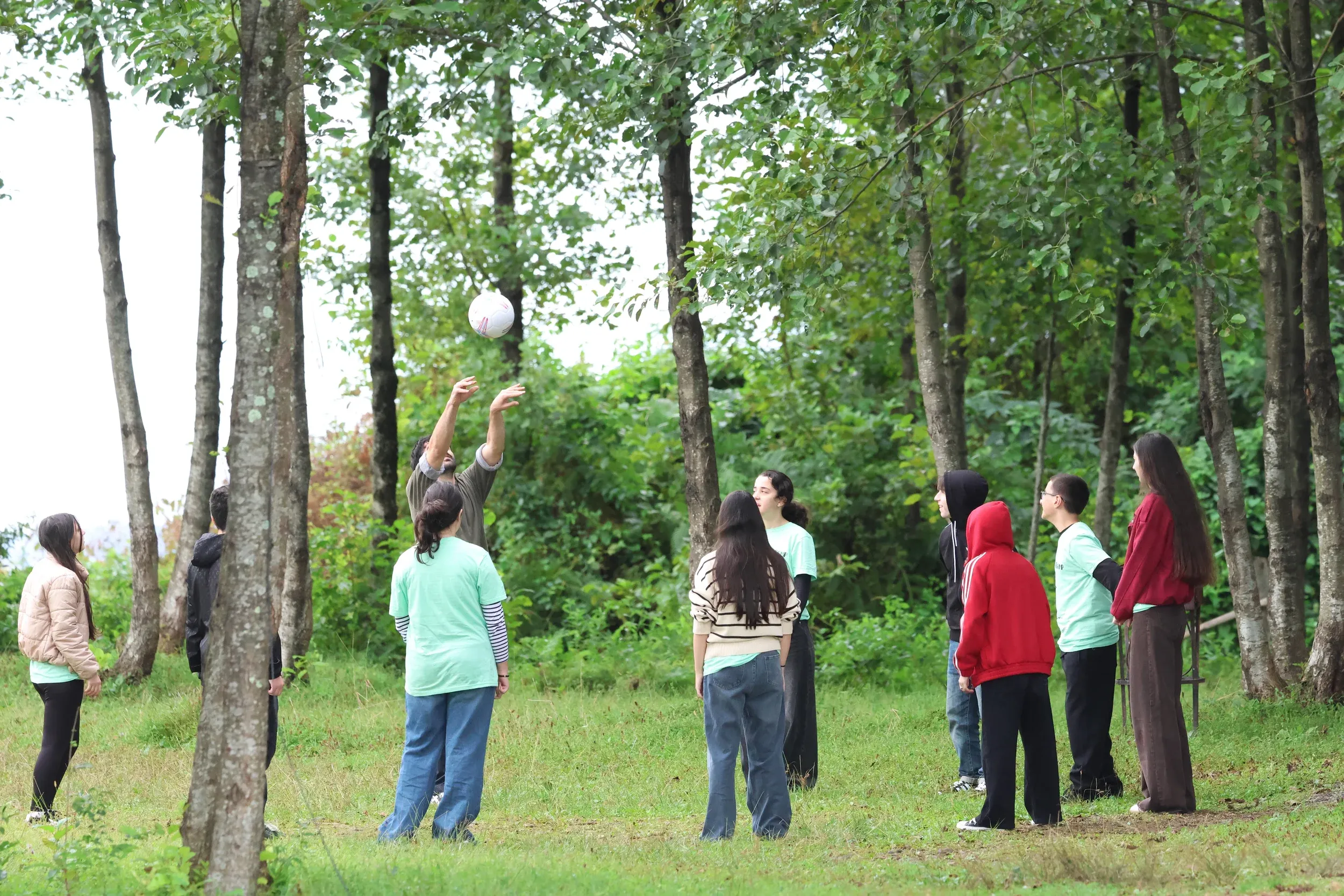 Students playing an outdoor game among the trees at bird camp